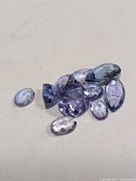 Group of loose blue-violet tanzanite stones on neutral background