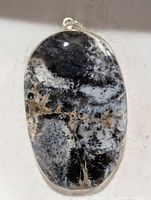 Front view of oval dendrite agate pendant in silver bezel