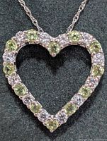 Close-up of heart pendant showing peridot and clear stones