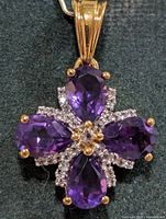 Front view of amethyst cluster pendant showing four pear-shaped stones and clear accents