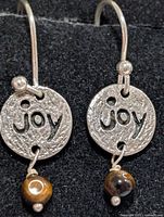 Front view of earrings showing JOY discs and tiger eye beads