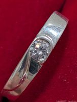 Top view of silver ring showing cubic zirconia stone and swirl detail