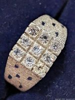 Front view of silver ring showing twelve clear stones in grid pattern