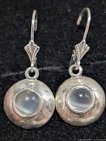 front view of both earrings showing moonstone cabochons and silver discs