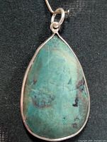 Front view of teardrop turquoise pendant with silver bezel and bail
