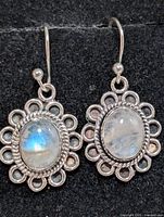 Front view of earrings showing moonstones and floral silver frames