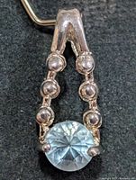 Front view of sterling pendant showing blue topaz and bead accents