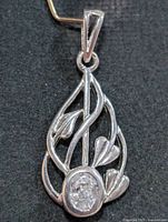Front view of sterling silver pendant showing vine design and oval CZ