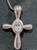 Full view of silver cross pendant showing central CZ stone and bail