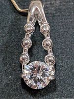 Front view of silver-tone pendant with cubic zirconia
