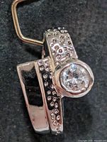 Front view of silver pendant showing CZ stone and dotted design