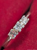 Oblique view of ring showing three clear stones in prong settings