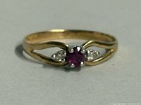 Front view of yellow gold ring with ruby and diamonds