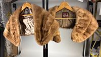 Front view of both mink stoles on hangers