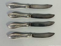 Four fish knives displayed full length