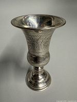 Oblique view of sterling Kiddush cup showing overall form and engraving