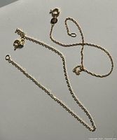 Both gold chain bracelets laid out showing length and clasps