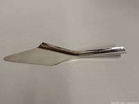 Full view of silver-plated cake server, handle to blade