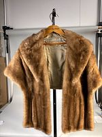 Front view of brown mink stole on hanger showing overall style and length