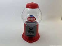 Front view showing full gumball machine with logo, base, globe, coin mechanism