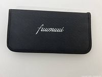 Closed black fabric case showing Fuumuui logo