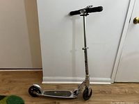 Full view of silver Micro kick scooter standing upright