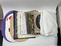 Stacked vintage placemats, bun warmer and white fabric on backdrop