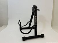 Front angled view of Quik Lok guitar stand showing uprights, padded arms and logo