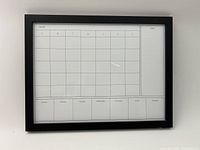 Front view of framed whiteboard calendar showing full grid and notes section