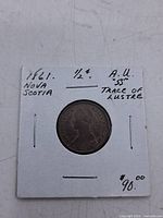 Coin in flip front showing obverse and handwritten details