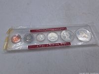Front view of entire six-coin set sealed in plastic sleeve