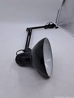 Full view of black adjustable desk lamp with clamp