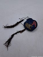 Full view of blue silk pouch with tassels extended