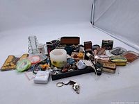 Group shot of entire lot showing jewelry, tins, candle, decor pieces and keychain