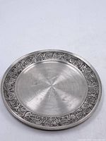 Full view of pewter plate showing entire design and raised rim
