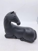 Side view of full matte black unicorn figurine with horn attached