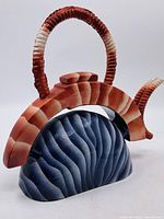 Full view of teapot showing handle, spout, body colors and form