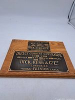 Front view showing both bronze nameplates mounted on oak plaque