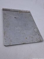 Front view of aluminum clipboard closed, showing surface wear