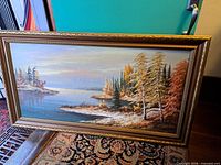 Full view of framed autumn lakeside painting showing composition and frame