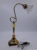 Full view of brass lamp showing base, arm, and cord