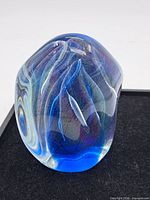 Front view of freeform blue iridescent glass paperweight