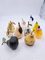 Group shot of all 10 pear figurines highlighting material and colour variety