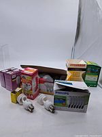 Assorted boxed and loose CFL bulbs with fuse box