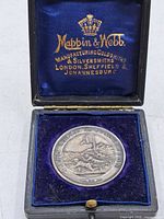 Medal in open fitted case showing maker’s gilt mark on satin lid and velvet pad