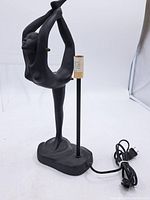 Full view of matte black resin dancer table lamp with cord