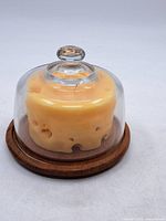 Candle covered by dome sitting on wooden base