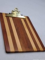 Front view of striped wood clipboard serving board