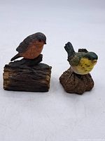 Both bird figurines side by side showing size and bases