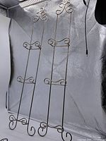 Full view of two of the wrought iron plate stands showing overall form and height